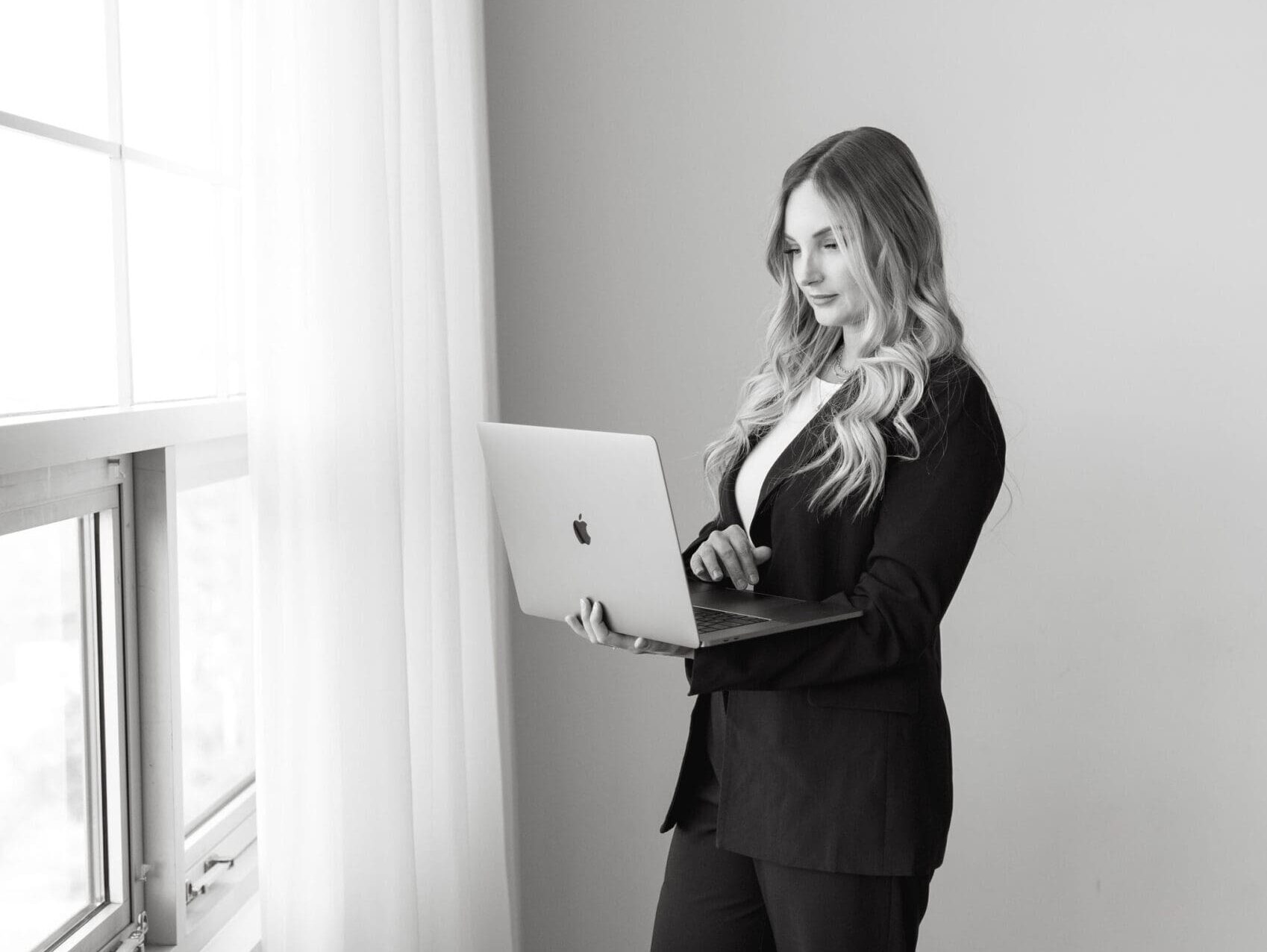 Karly Whitaker standing and using her laptop