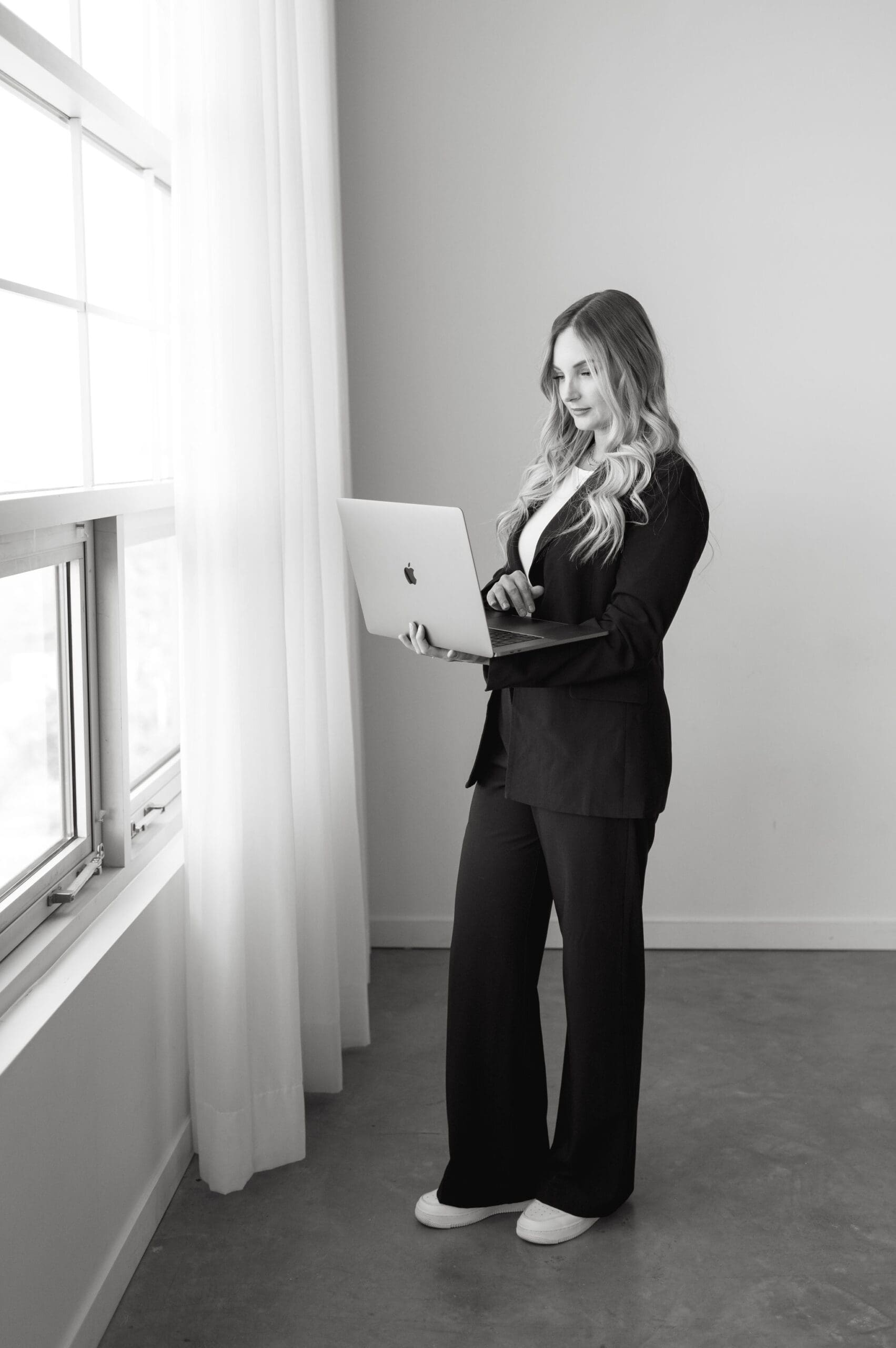 Karly Whitaker standing and using her laptop