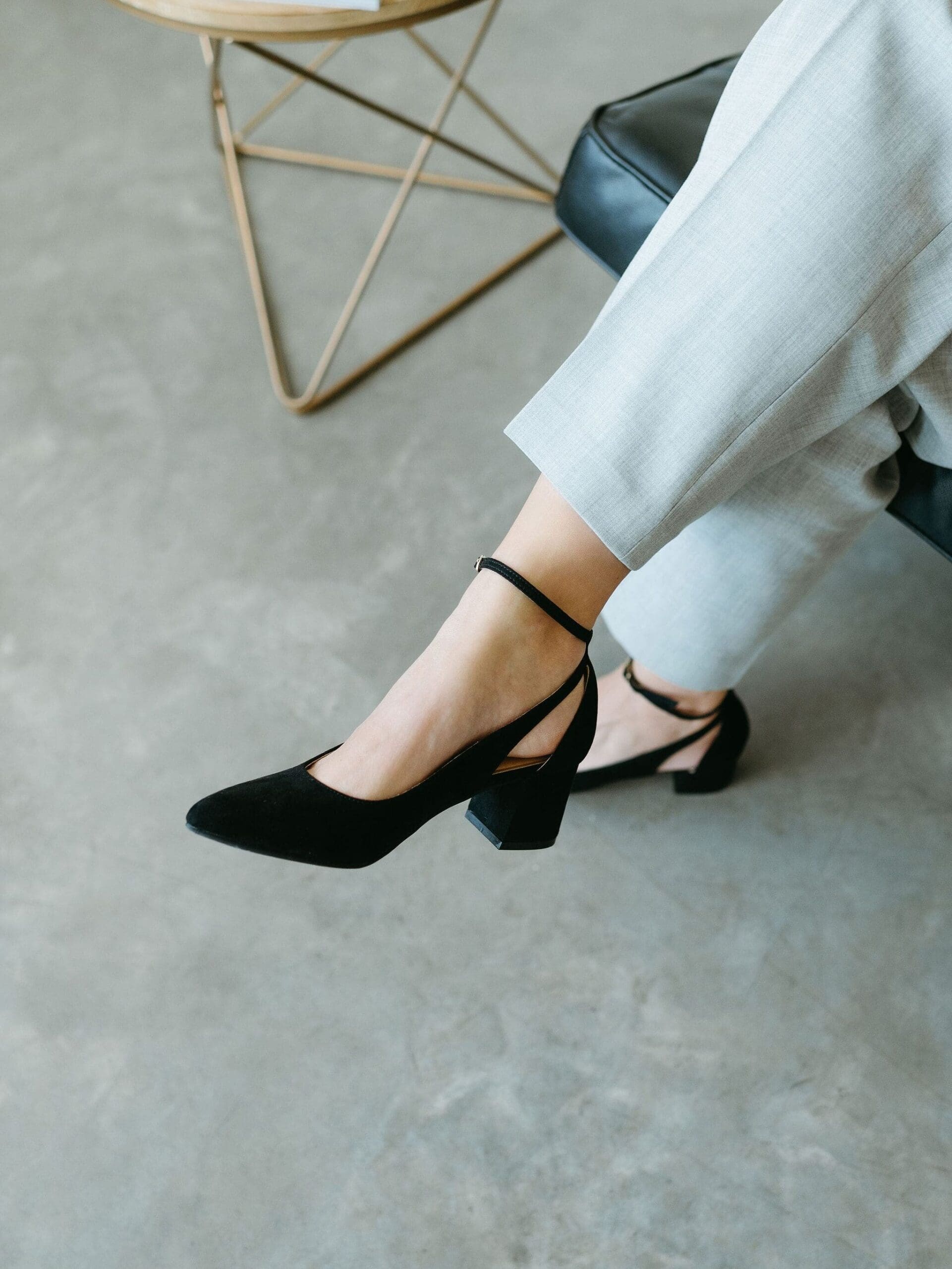 Close-up of professional heels and tailored pants near a modern side table, highlighting polished branding and attention to detail for creative business systems.