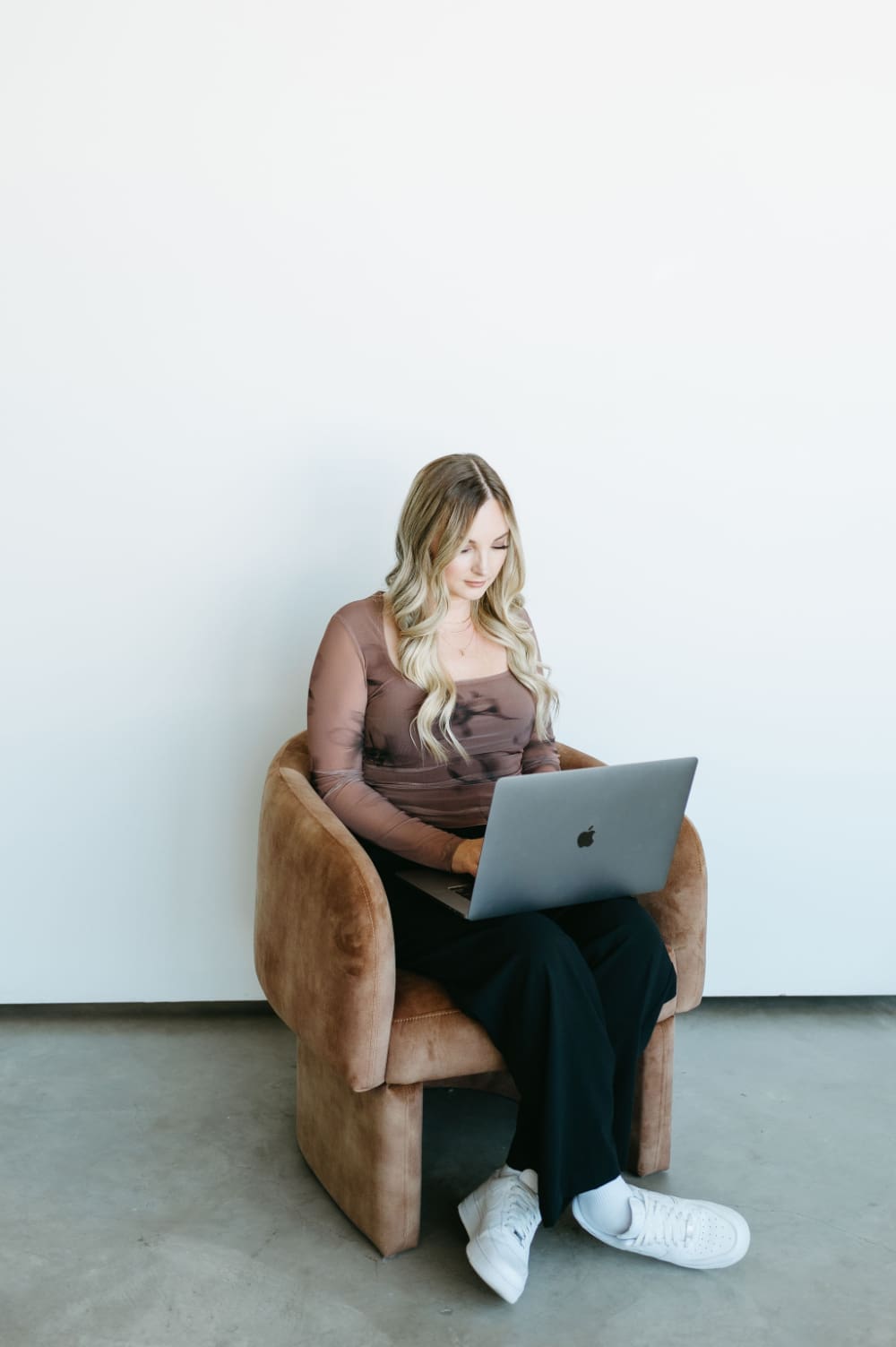 HoneyBook consultant working on a laptop while setting up client systems and automations using Zapier with HoneyBook for creative entrepreneurs.