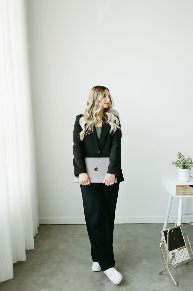 HoneyBook expert Karly Whitaker holding her laptop in a bright office